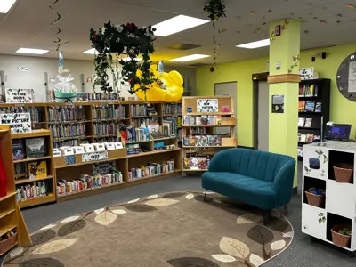 A wide angle shot of the Children's Department featuring summer decor such as vines, butterflies, and a large inflatable rubber ducky. 